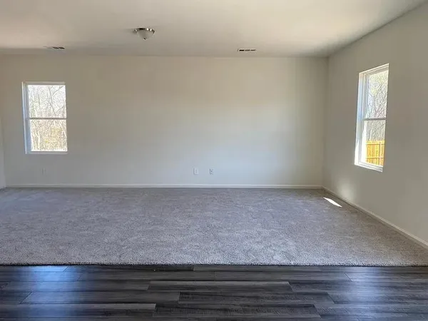 an empty room with wooden floor and window
