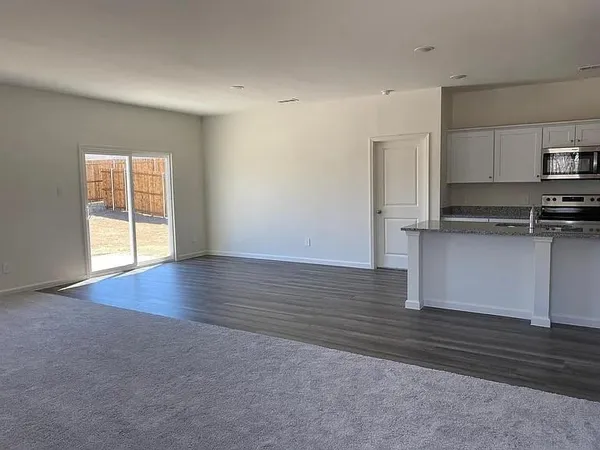 an empty room with wooden floor and window