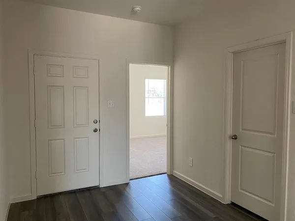 a view of an empty room and wooden floor