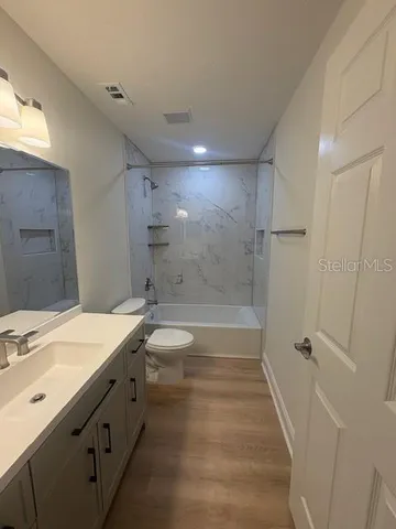 a bathroom with a double vanity sink toilet mirror and shower