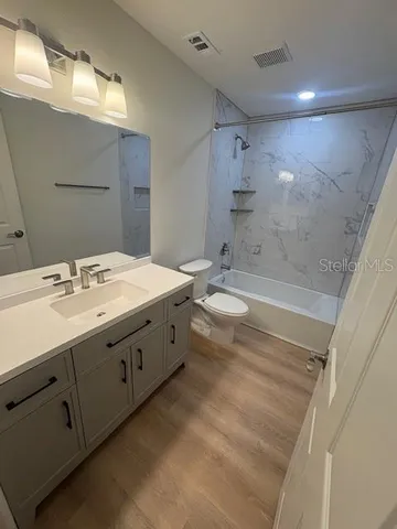 a bathroom with a double vanity sink mirror and bathtub