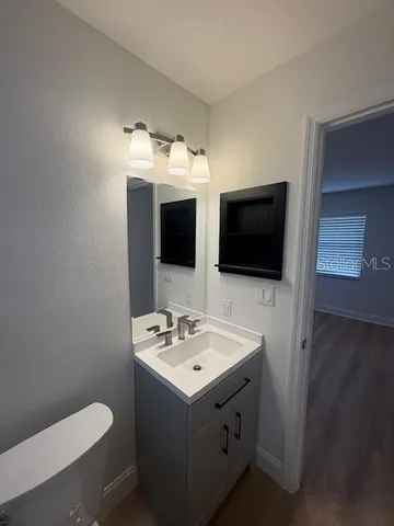 a bathroom with a toilet sink and mirror