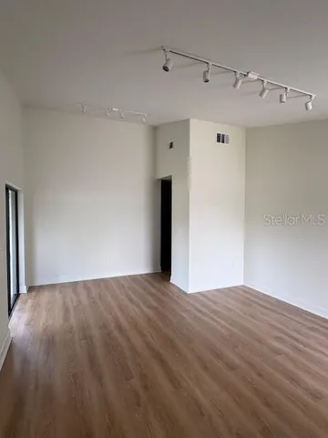 a view of an empty room with wooden floor