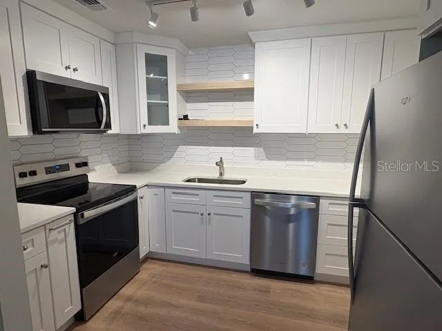 a kitchen with a sink stove and microwave