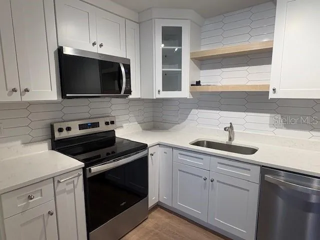 a kitchen with white cabinets and stainless steel appliances