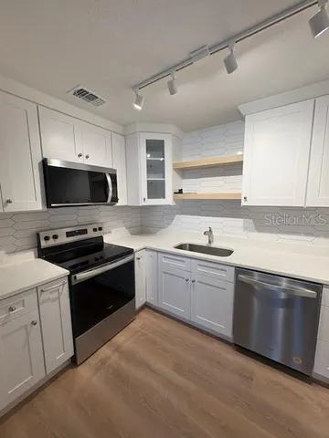 a kitchen with stainless steel appliances granite countertop a stove and a sink