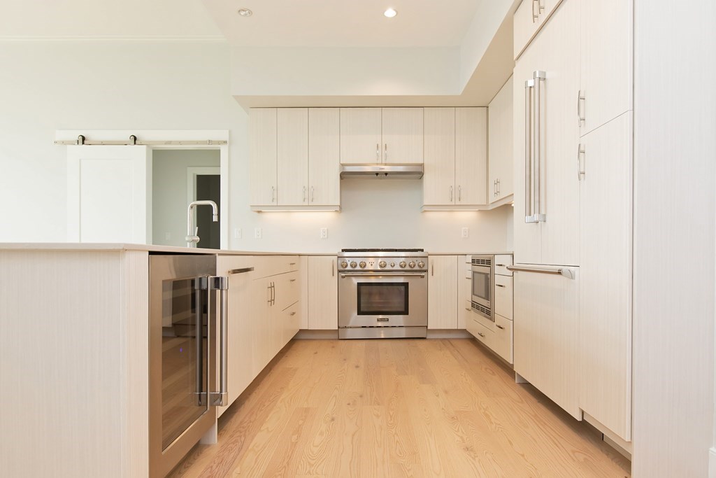 10 Shipyard Drive, Unit 517 Hingham, MA 02043 - Photo 4 of 14 a kitchen with white cabinets and white appliances