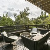 a roof deck with table and chairs and wooden floor