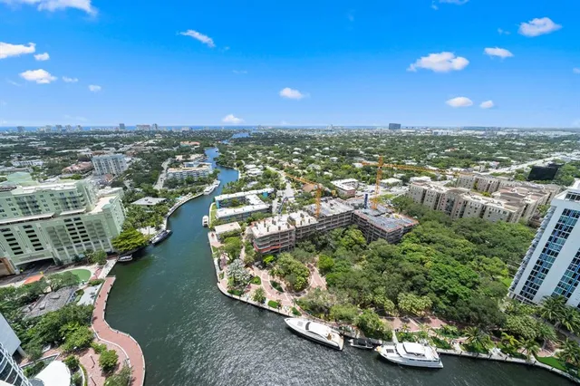 an aerial view of a house with a yard and lake view in back