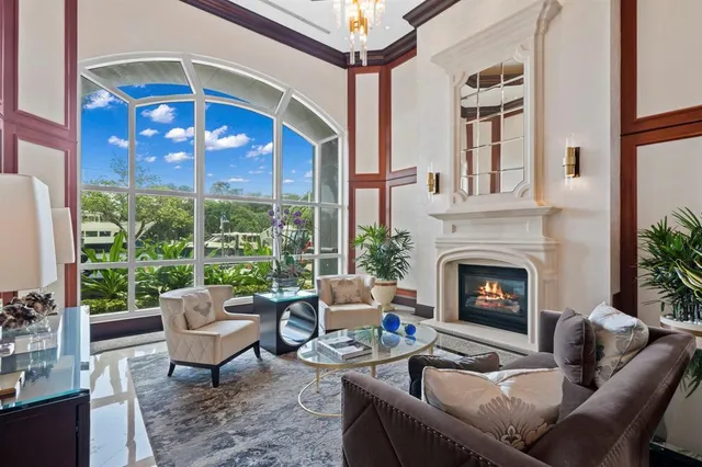 a living room with furniture a fireplace and a floor to ceiling window