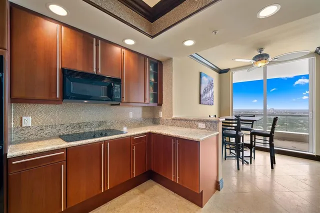 a kitchen with a sink a microwave and chairs