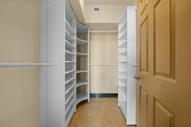 a view of walk in closet with empty racks
