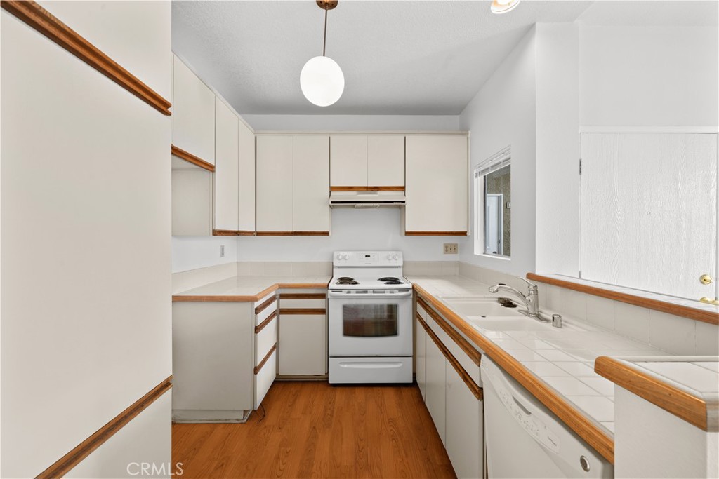27645 Susan Beth Way, Unit A Saugus, CA 91350 - Photo 9 of 26 a kitchen with a sink cabinets stainless steel appliances and a window