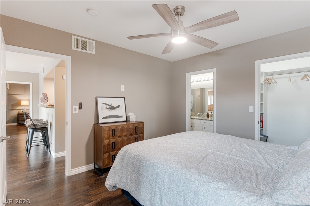 7255 West Sunset Road, Unit 2155 Las Vegas, NV 89113 - Photo 17 of 21 Bedroom featuring dark wood-style floors, a walk in closet, ceiling fan, and ensuite bath