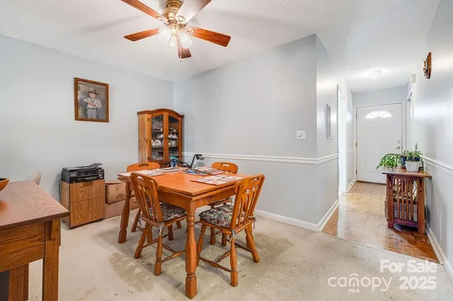 a dining room with a table chairs and a kitchen view