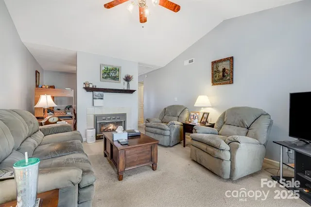 a living room with furniture a fireplace and a flat screen tv