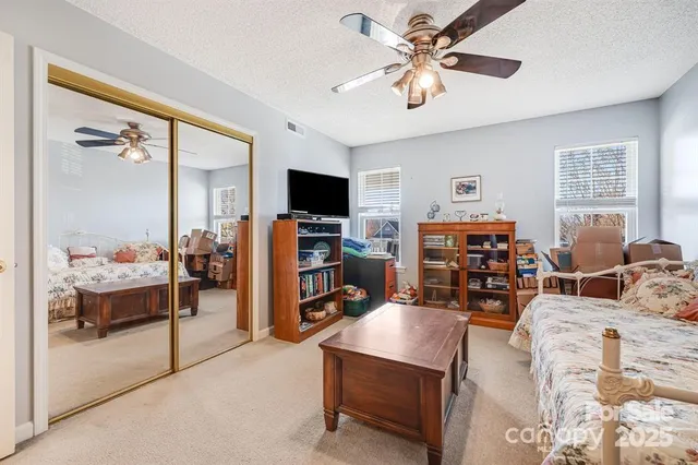 a living room with furniture a ceiling fan and a window