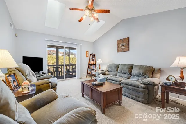 a living room with furniture ceiling fan and a window