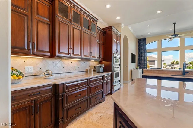 a kitchen with stainless steel appliances granite countertop wooden cabinets a stove and a sink