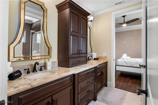 a en suite bathroom with a granite countertop sink and a mirror