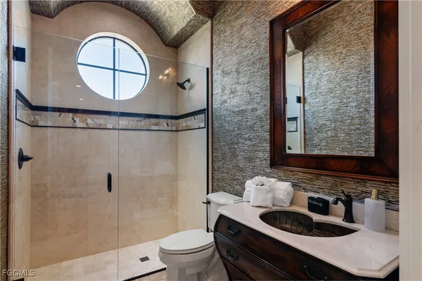 a bathroom with a sink a toilet and shower