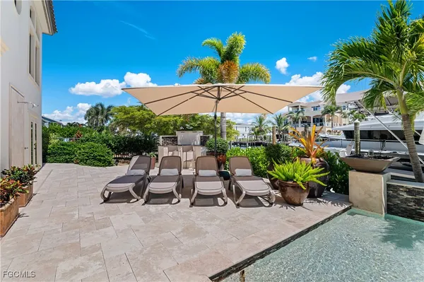 a view of a patio with chairs and a table under an umbrella