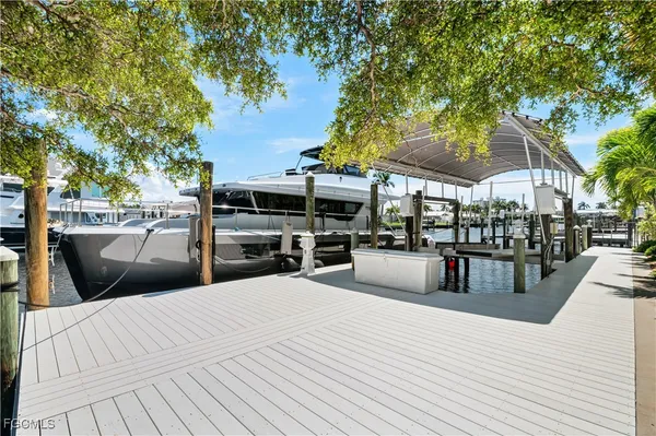 a view of a patio with dining table and chairs with wooden floor and fence