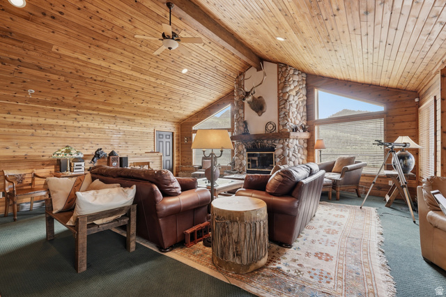 6 Beaver Springs Rancheros Oakley, UT 84055 - Photo 6 of 68 Vaulted wood-paneled ceilings with exposed beams, a floor-to-ceiling stone fireplace, and triangular transom windows define this expansive living area