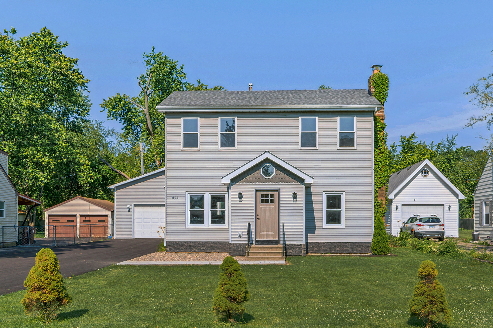 825 South Prairie Road New Lenox, IL 60451 - Photo 2 of 42 a front view of a house with a garden and plants