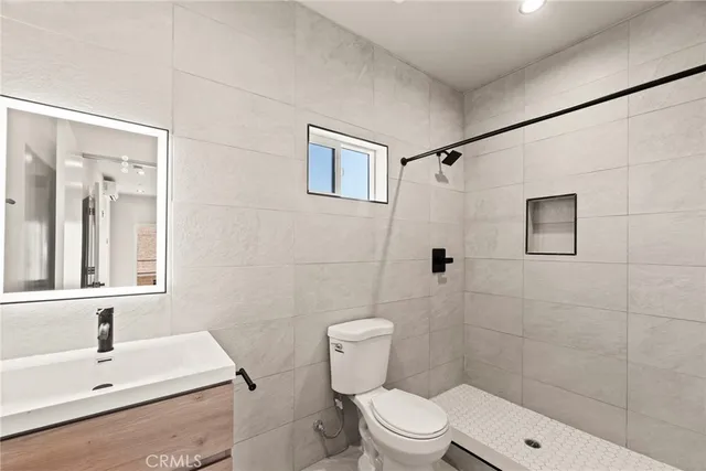 a bathroom with a sink a toilet and shower