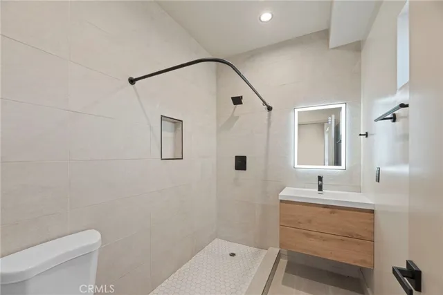 a bathroom with a sink mirror toilet and shower