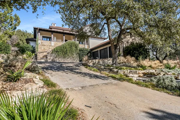 a view of a house with a yard covered with trees