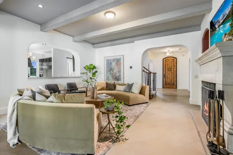 a living room with furniture a fireplace and a chandelier
