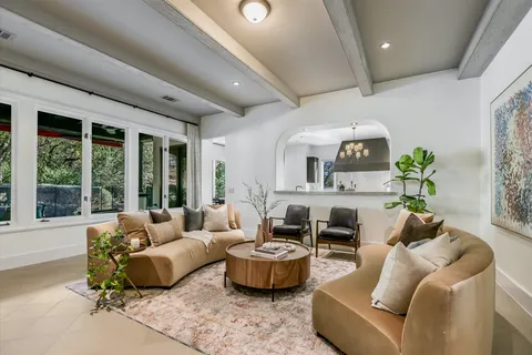 a living room with furniture fireplace and a large window
