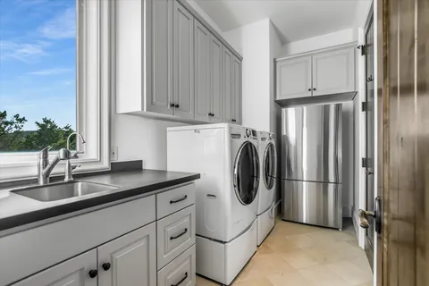 a kitchen with stainless steel appliances a refrigerator a sink and cabinets