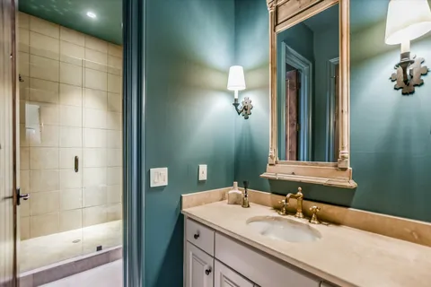 a bathroom with a granite countertop sink a mirror and a shower