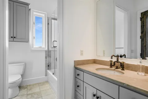 a bathroom with a granite countertop sink toilet and shower