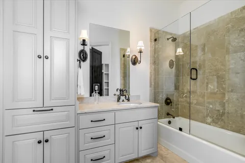 a bathroom with a tub sink shower and mirror