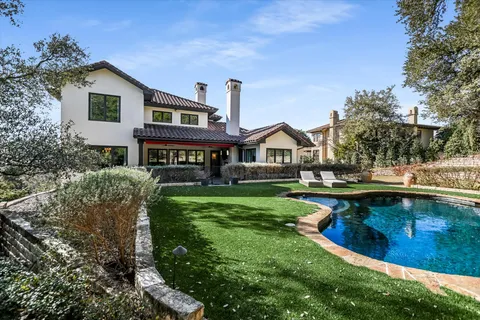a view of a house with swimming pool and a yard
