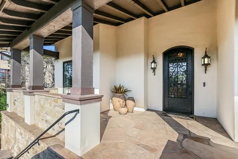 a view of a hallway with entryway and wooden floor