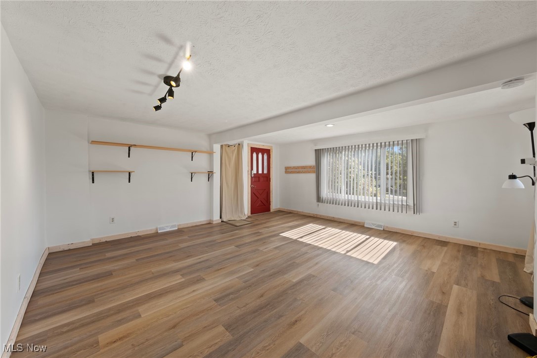 793 Chaffin Road Akron, OH 44306 - Photo 5 of 28 Unfurnished living room featuring hardwood / wood-style flooring and a textured ceiling