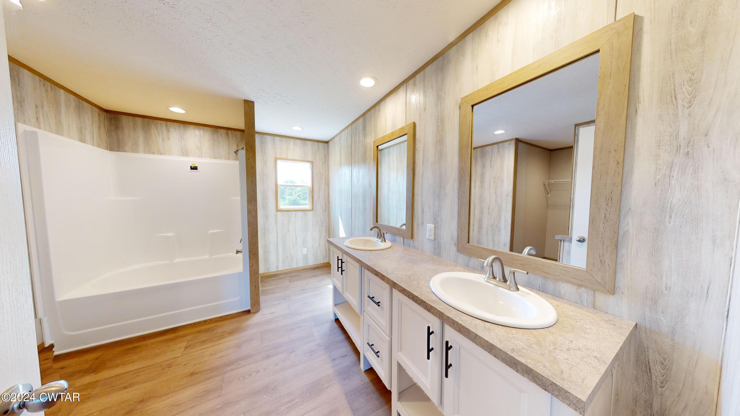 463 Peckerwood Point Road Newbern, TN 38059 - Photo 16 of 35 a bathroom with double vanity and a mirror