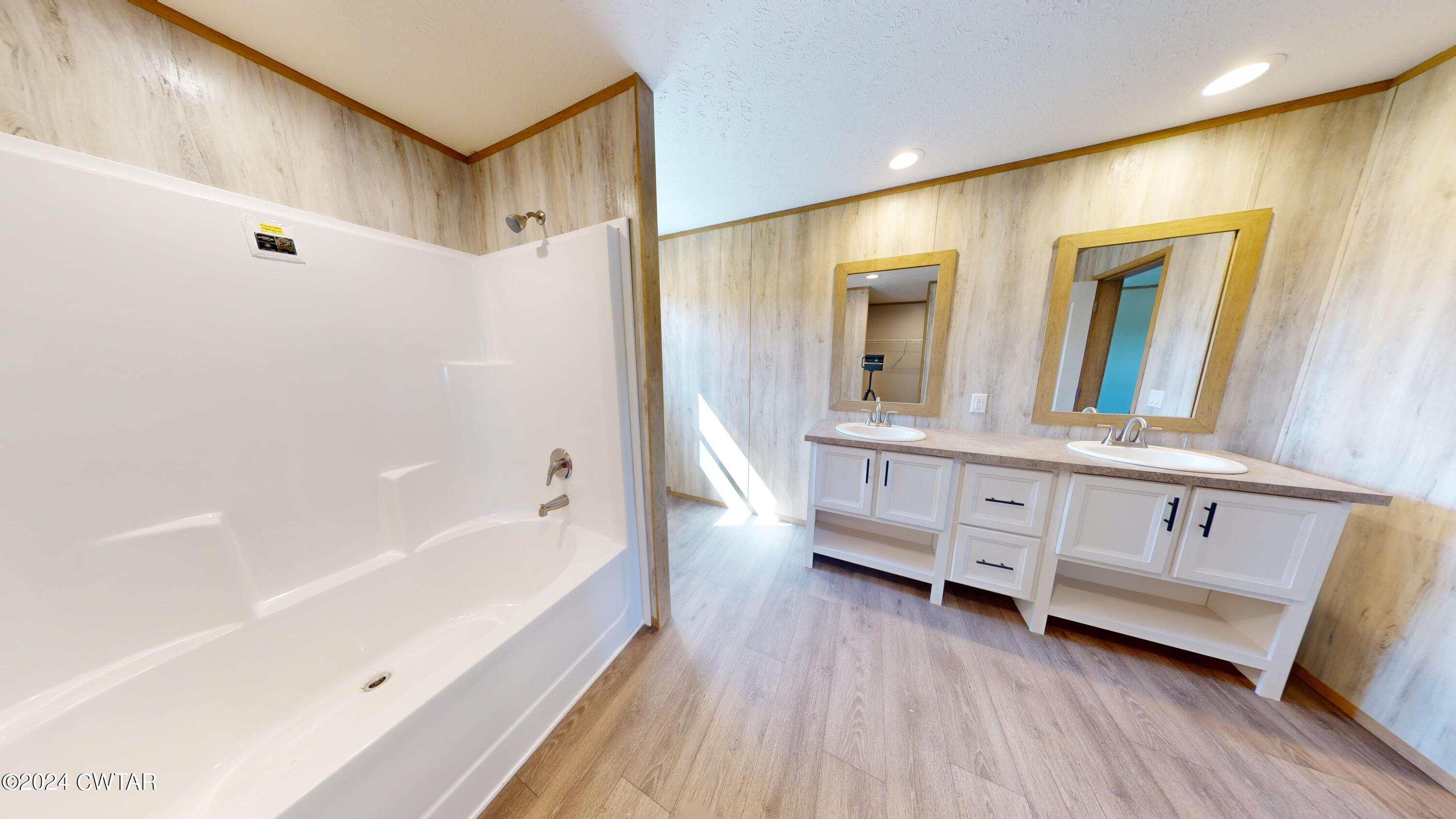 463 Peckerwood Point Road Newbern, TN 38059 - Photo 17 of 35 a bathroom with a double vanity sink and a bathtub