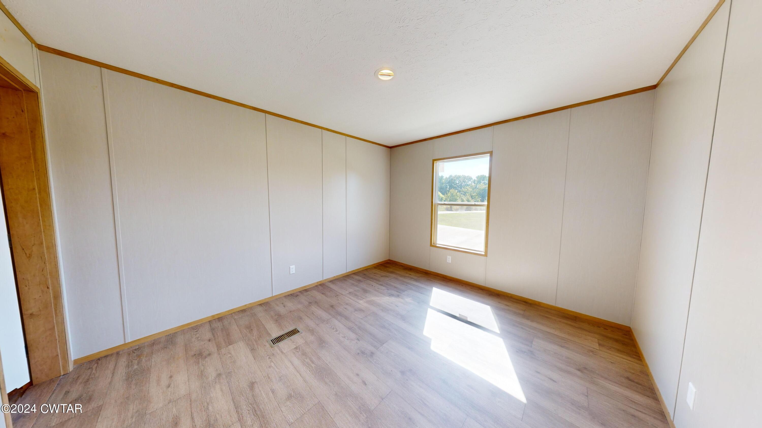463 Peckerwood Point Road Newbern, TN 38059 - Photo 21 of 35 a view of an empty room with wooden floor and a window
