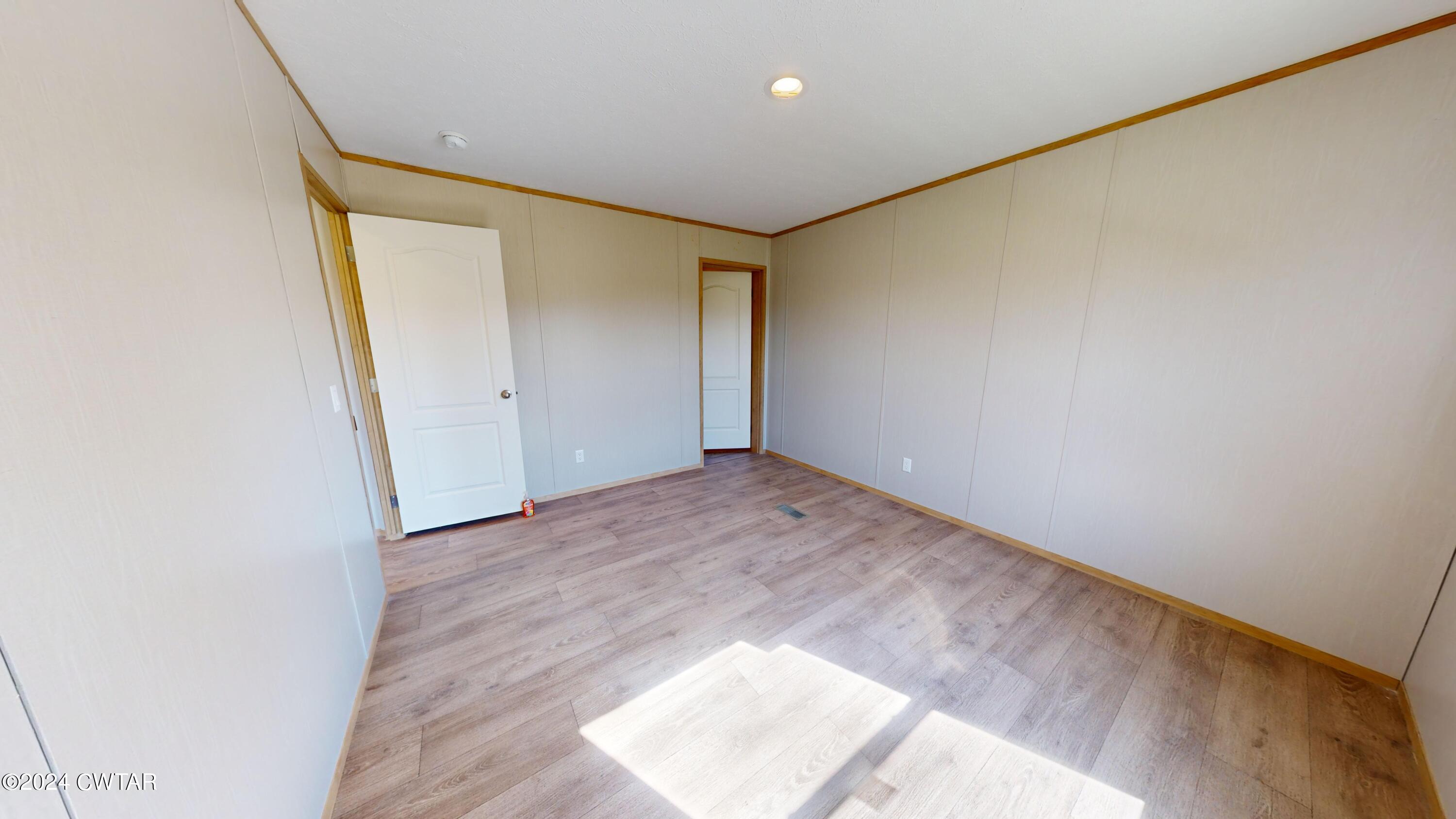 463 Peckerwood Point Road Newbern, TN 38059 - Photo 22 of 35 an empty room with wooden floor and a window