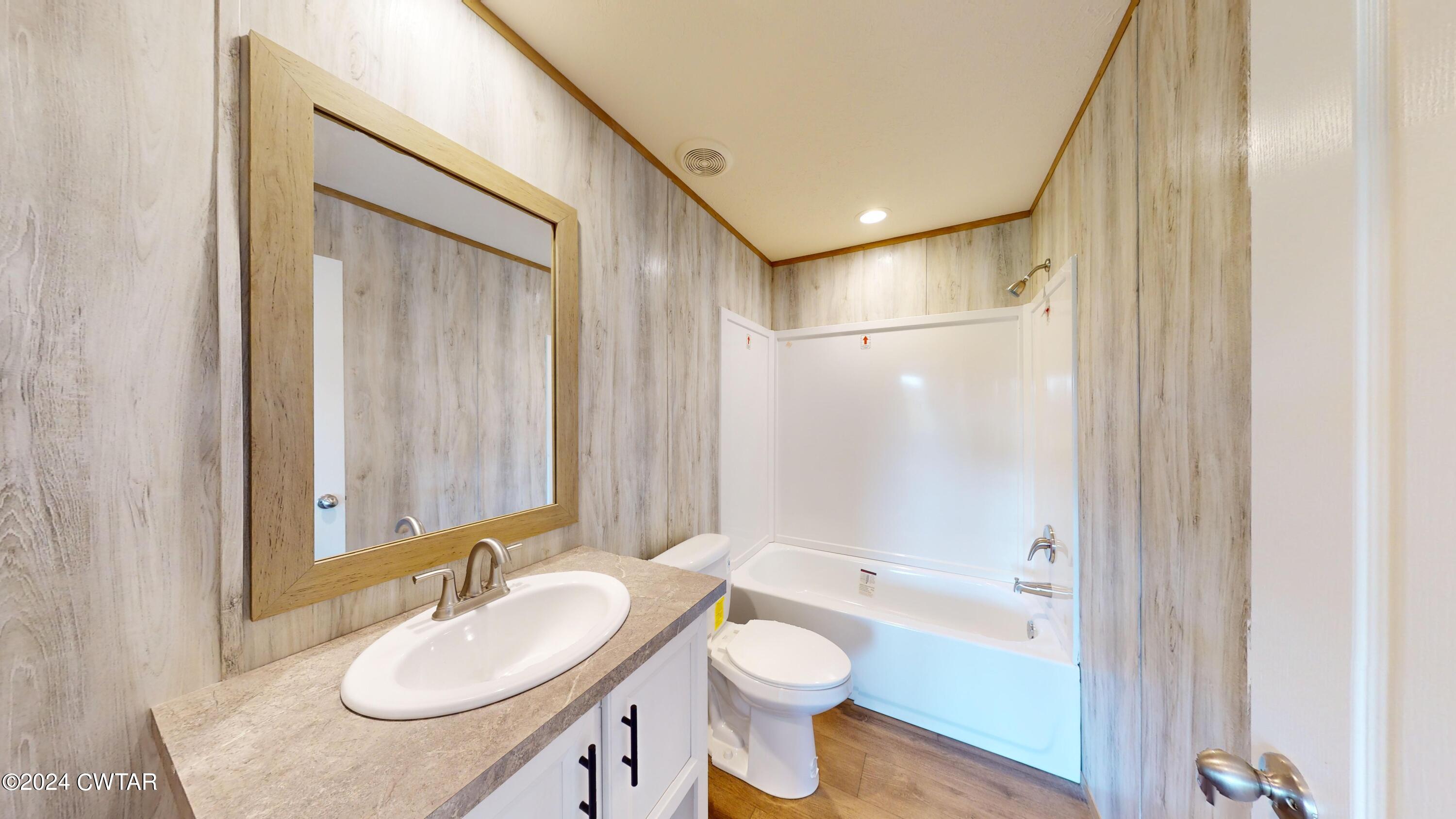 463 Peckerwood Point Road Newbern, TN 38059 - Photo 24 of 35 a bathroom with a sink a toilet and shower a mirror