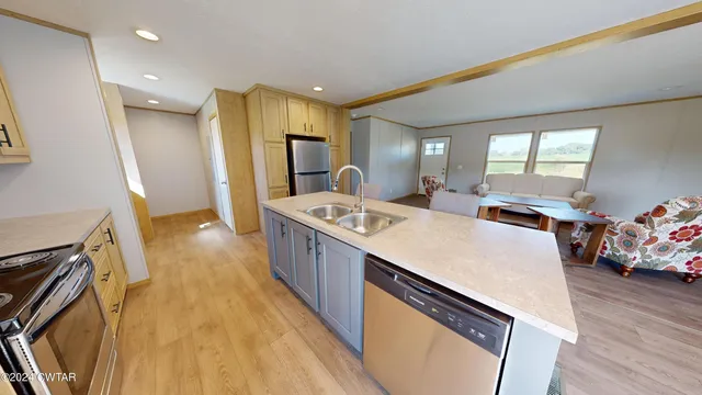 a large white room with a sink a window and a refrigerator