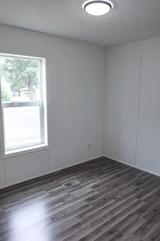 a view of a room with wooden floor and a window