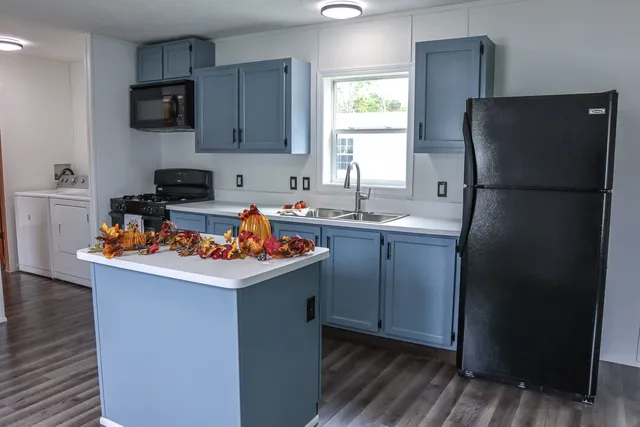 a kitchen with a sink a refrigerator and a stove top oven