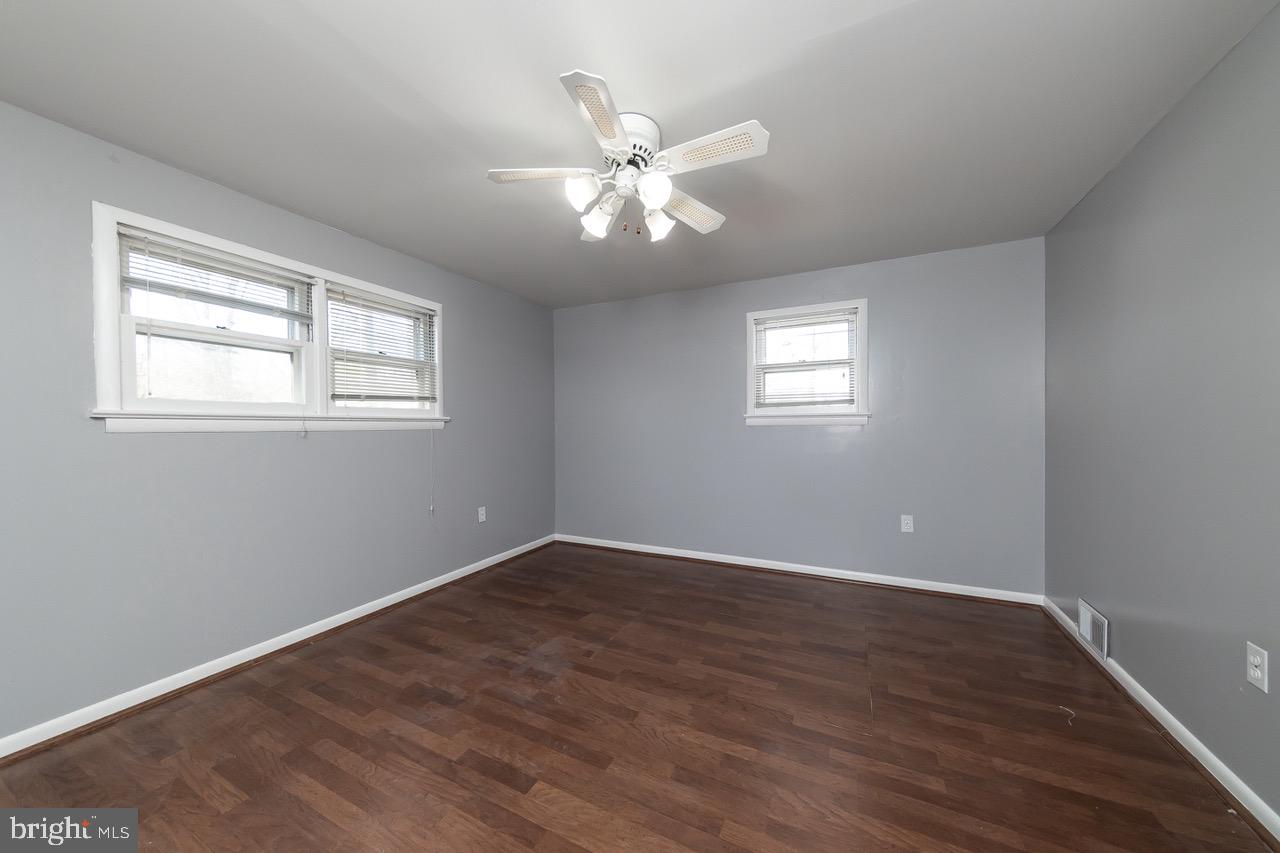 112 East 7th Avenue Pine Hill, NJ 08021 - Photo 13 of 27 an empty room with wooden floor windows and fan